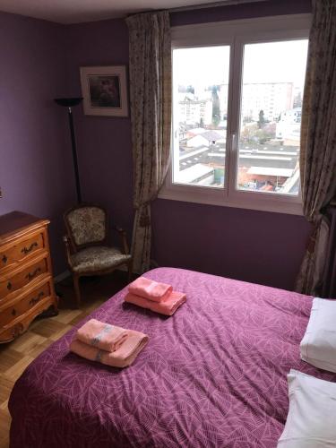 - une chambre avec un lit violet et 2 serviettes dans l'établissement Suite Clémenceau 82, à Reims