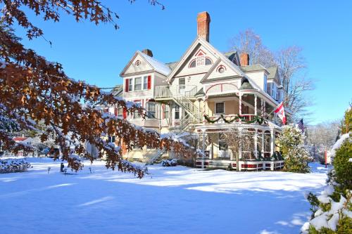 a large house with snow on the yard at Wainwright Inn in Great Barrington