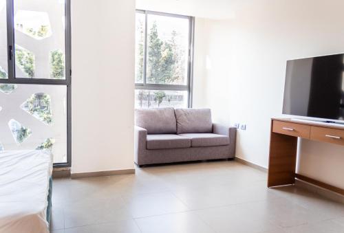 a living room with a chair and a television at Amwaj Apartments in Nazareth