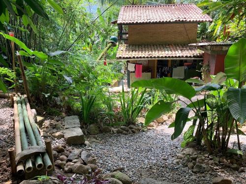 un jardín frente a una casa con un edificio en Camping Trópico de Capricórnio - Ilhabela, en Ilhabela