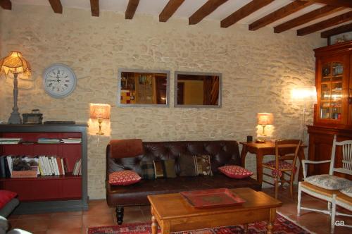 a living room with a couch and a table at Le GITE du MAS des CLOTS in Upie