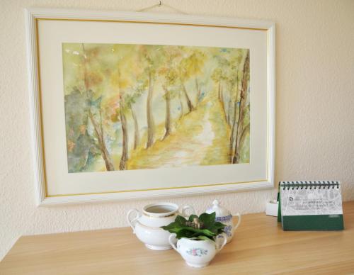 a painting on a wall with a table with a painting at Schloms Hof in Waffensen