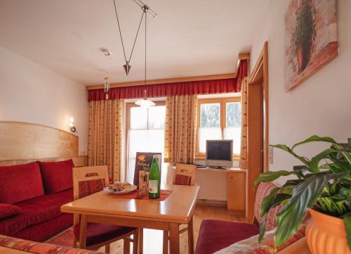 - un salon avec un canapé rouge et une table dans l'établissement Zeiserhof, à Ramsau am Dachstein