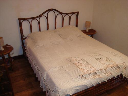 ein Schlafzimmer mit einem Bett mit einer weißen Bettdecke in der Unterkunft villa ROSE GARDEN in Craponne-sur-Arzon
