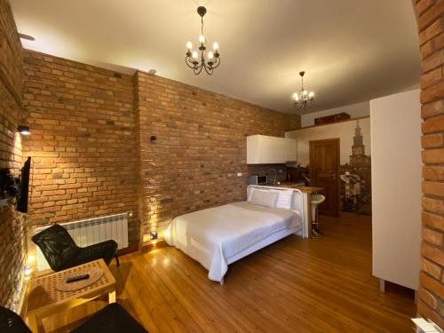 a bedroom with a bed and a brick wall at My place in Poznan in Poznań