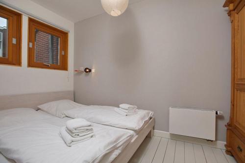Un dormitorio con una cama con toallas. en Bungalow-M, en Westerland