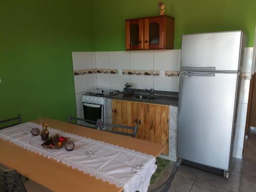 uma cozinha com uma mesa e um frigorífico branco em Alojamiento 1 Lili y Víctor em Puerto Iguazú