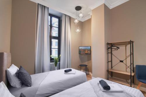 sypialnia z dwoma łóżkami i oknem w obiekcie Apartamenty Oliwka w Elblągu