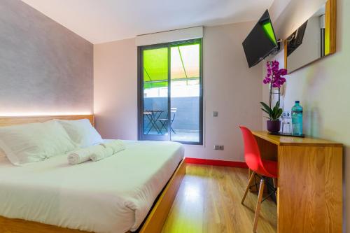 sypialnia z łóżkiem, biurkiem i oknem w obiekcie Ok Hostel Madrid w Madrycie