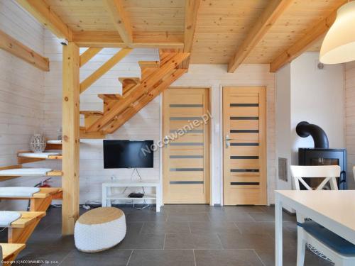 a living room with wooden ceilings and a tv at Ciche Wydmy in Sasino