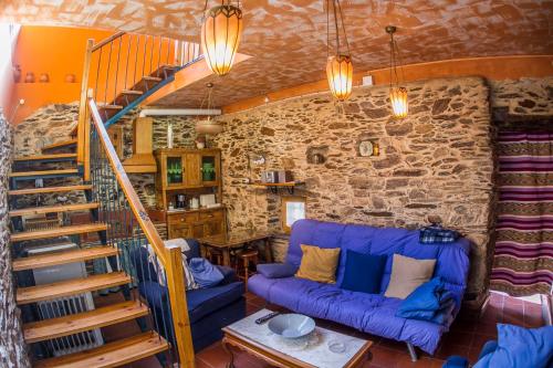 a living room with a blue couch and a staircase at Casa Rural El Cartero in Carpio de Azaba