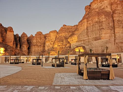 a group of buses parked in front of a mountain at Shaden Resort in AlUla