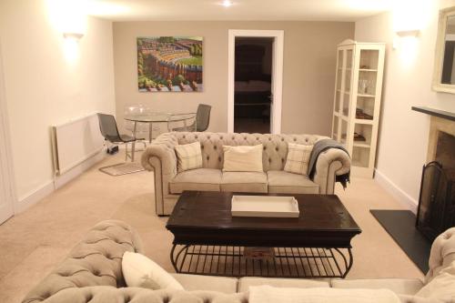 a living room with a couch and a table at Bath Garden Apartment in Bath