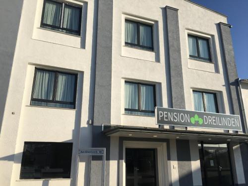 a building with a sign in front of it at Pension Dreilinden Hannover GmbH in Hannover