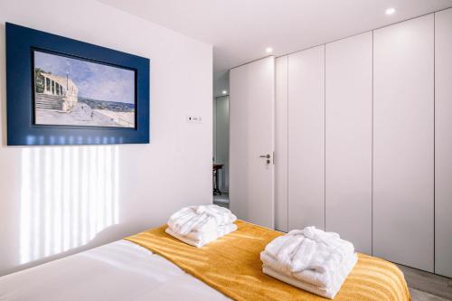 1 dormitorio con 1 cama con 2 toallas en BBA Apartments Palácio I - Douro View & Parking, en Oporto