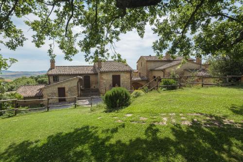 an old stone house with a green yard at Agriturismo Cerreto in Pienza