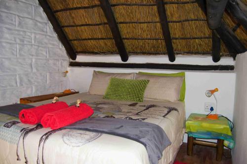 a bedroom with a bed with two red towels on it at Suzie's Loft - NUDE - SunEden Family Naturist Resort in Pretoria