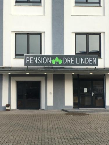 un bâtiment avec un panneau à l'avant dans l'établissement Pension Dreilinden Hannover GmbH, à Hanovre