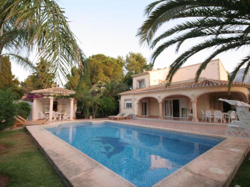 a swimming pool in front of a house at Belvilla by OYO Somontes in Denia