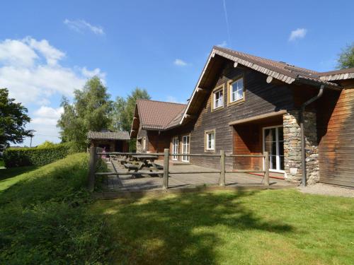 een huis met een picknicktafel ervoor bij Spacious chalet in Ovifat Waimes with sauna in Ovifat