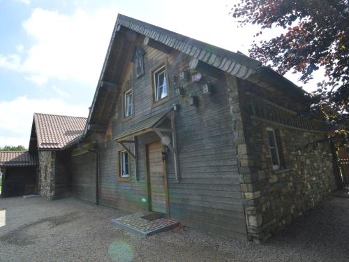 een groot houten gebouw met een deur erop bij Spacious chalet in Ovifat Waimes with sauna in Ovifat