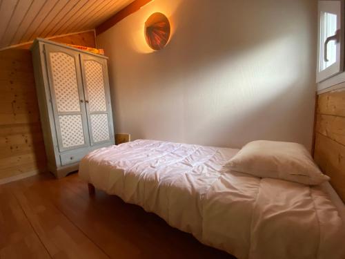 a bedroom with a white bed and a window at le montanet in Thollon