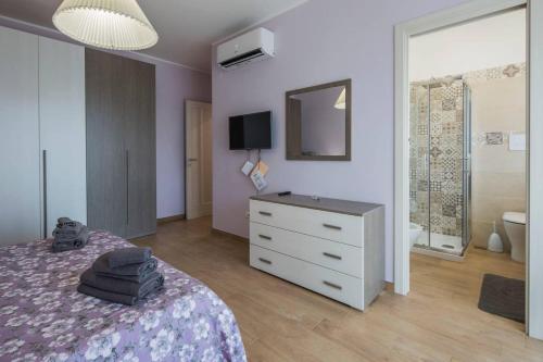 a bedroom with a bed and a dresser and a mirror at B&B La Tinta in Baronissi