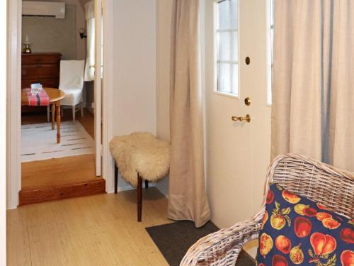 um quarto com uma porta, uma cadeira e uma mesa em Holiday home HARPLINGE II em Harplinge