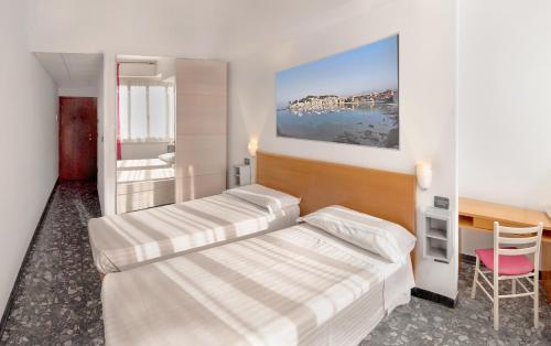 1 dormitorio con 2 camas, escritorio y silla en Villa Pozzi, en Sestri Levante