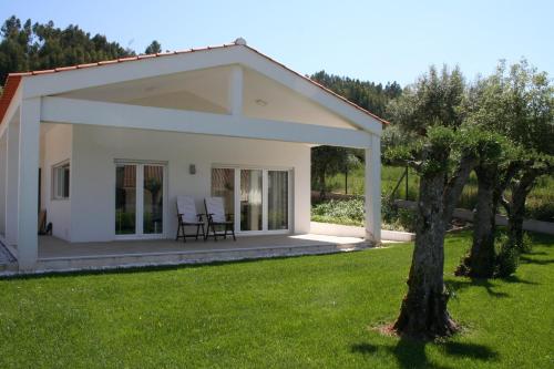 a small white house with two chairs in a yard at Encosta da Camarinha in Ferreira do Zêzere