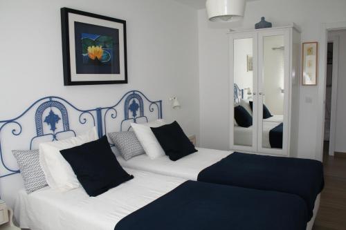 een slaapkamer met 2 bedden en zwarte en witte kussens bij Encosta da Camarinha in Ferreira do Zêzere