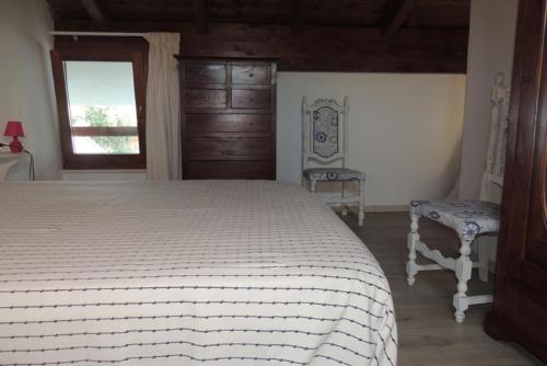a bedroom with a bed and two chairs and a window at SENAFER Funtana Meiga in Funtana Meiga