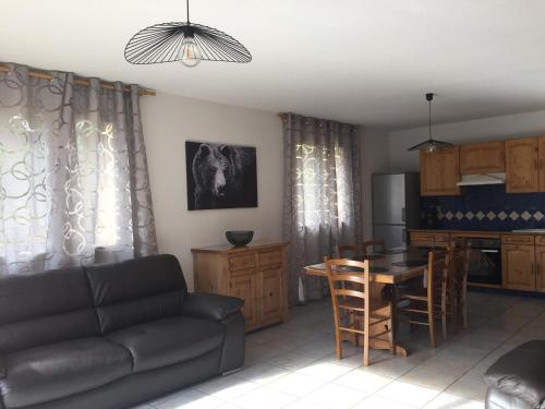 un salon avec un canapé et une table et une cuisine dans l'établissement gentianes bleues, à Saint-Jean-Saint-Nicolas