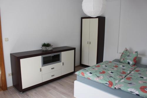 a bedroom with a bed and a cabinet with a microwave at Ferienwohnung am Fluss in Weischütz