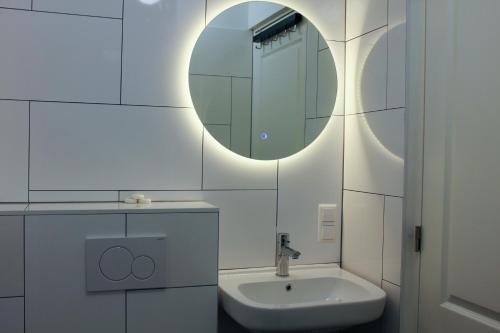 een witte badkamer met een wastafel en een spiegel bij Central Studios in Den Haag