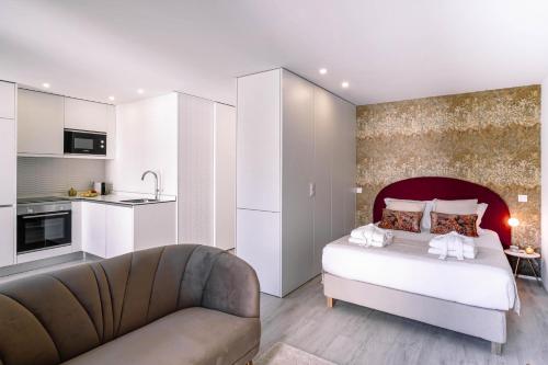 una camera con letto e divano e una cucina di BBA Apartments Palácio II - Garden View & Parking a Porto