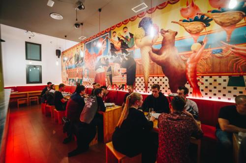 grupa ludzi siedząca przy stołach w restauracji w obiekcie Ok Hostel Madrid w Madrycie