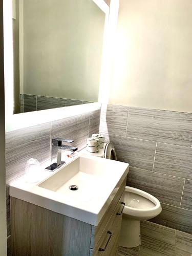 a bathroom with a sink and a toilet and a mirror at Tappan Zee Hotel in West Nyack