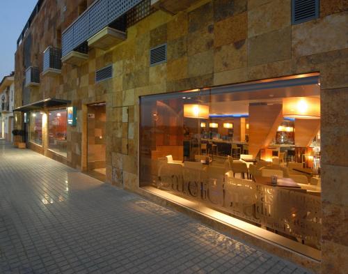 a building with a store window with chairs in it at Hotel Macami in El Carpio