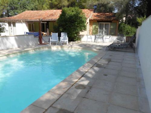 uma piscina com cadeiras e uma casa em Comfortable holiday home with private pool em Fayence