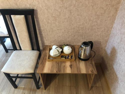 einen Tisch mit einem Stuhl und einem Wasserkocher in der Unterkunft Wander Kazbegi Hotel in Kazbegi