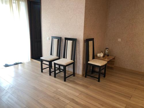 Zimmer mit 3 Stühlen und einem Tisch mit Spiegeln in der Unterkunft Wander Kazbegi Hotel in Kazbegi