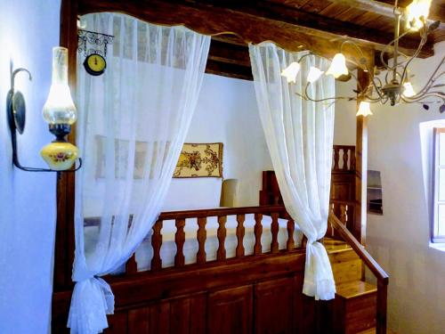 Mandrákionにある«Astrofeggia» A private stone house Nature-Seaviewの白いカーテンと階段の手すりが備わるお部屋