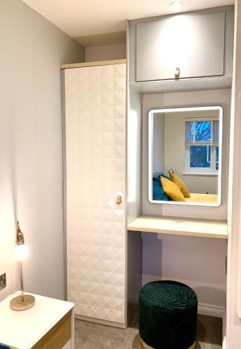 a bathroom with a mirror and a stool in a room at Stylish Cambridge Pad in Bar Hill