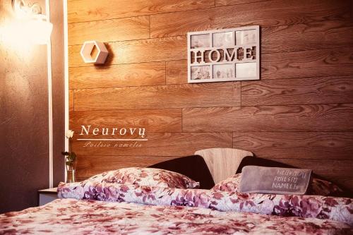 a bedroom with a bed and a sign on the wall at Neurovu poilsio namelis in Vilkyčiai