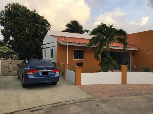a blue car parked in front of a house at Luna 39 in Oranjestad