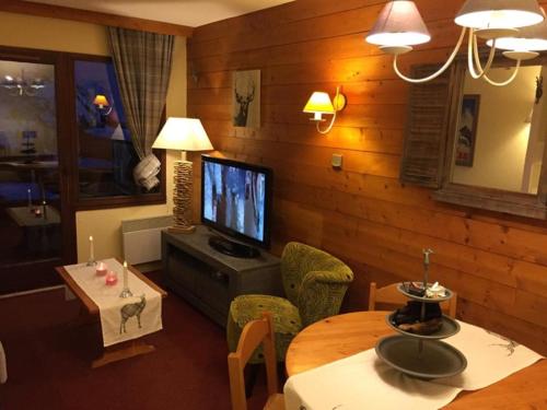 a living room with a television and a table and chairs at Coquet studio Quartier Falaise superbe vue in Avoriaz