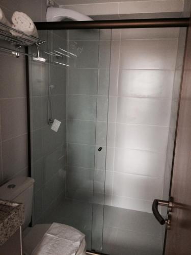 a shower with a glass door in a bathroom at Manaíra Apart Hotel in João Pessoa
