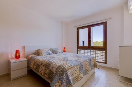 ein weißes Schlafzimmer mit einem Bett und einem Fenster in der Unterkunft Ténis Golf Mar - 1 bedroom Apartment - Vilamoura in Vilamoura