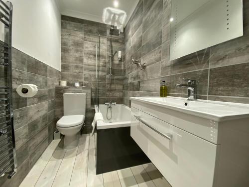 uma casa de banho com um lavatório, um WC e uma banheira em Camelia Hotel em Southend-on-Sea